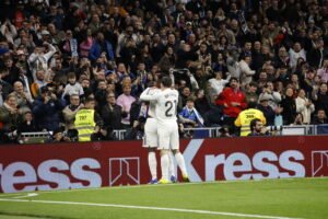 Futbolistas del Real Madrid abrazándose en grupo para celebrar un gol contra el Rayo Vallecano.
