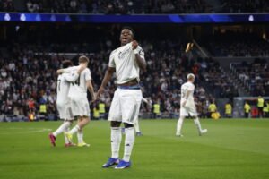 El delantero Vinícius Júnior celebrando con euforia un gol frente a la grada en el Santiago Bernabéu.